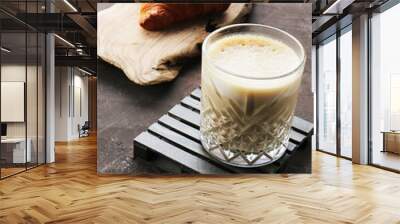 Glass of latte and croissant on a dark background Wall mural