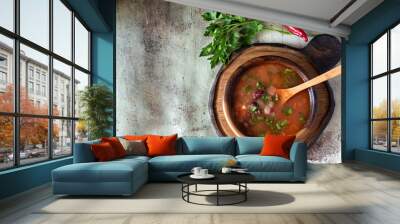 Spicy tomato soup with beans on a wooden plate on a gray background Wall mural