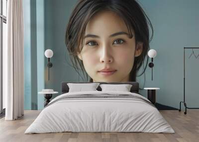 A young Asian business woman smiles at the camera, standing in the pose of a woman about 30 years old in a suit, the portrait was shot in the studio. Portrait of a business woman. Wall mural