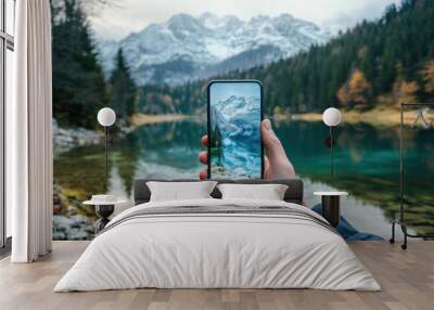 hand holding smartphone in the beautiful scenery with lake Wall mural