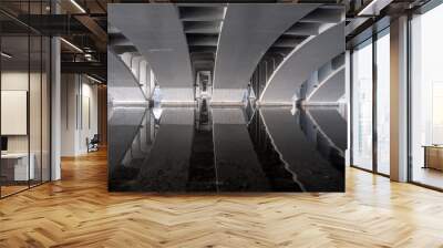 Arches of a concrete bridge with reflection in the water. Wall mural