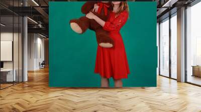 Beautiful woman in red dress hugging a teddy bear Wall mural