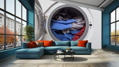 Open door in washing machine with laundry inside. Wall mural