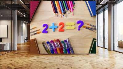 arithmetic example 2 plus 2 equals a question mark on the table around the book pencils fountain pens the concept of education school Wall mural