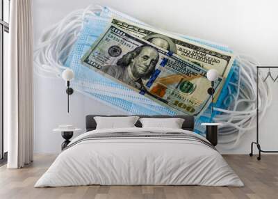 medical hygiene masks stacked in a stack are covered with two hundred dollar bills Wall mural