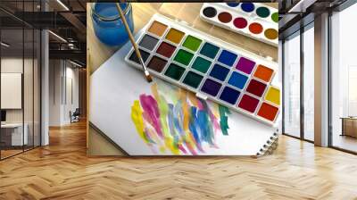 watercolor paints brush jar of water on a white sheet with samples of paints Wall mural