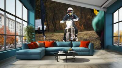 Professional enduro motorcycle rider in sport gear starts, a person participates  in motocross cross-country competition, active lifestyle Wall mural