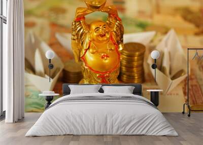 Golden Buddha statue close-up. Paper boats with coins in the background. Wall mural