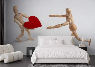 one wooden mannequin running towards another who is holding a heart and leaning back Wall mural