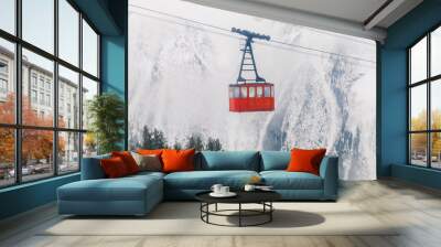 Red Ski lift in the background of the winter mountains. The red trailer of the old cable car moves to the mountain top of the ski resort. Retro gondola. Wall mural