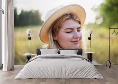 Romantic close up portrait o charming blonde girl in straw hat on the sunset nature, Warm sunset colors. Wall mural