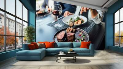 Close up photo, woman ready to eat medium rare beef steak while sitting in modern restaurant. Wall mural