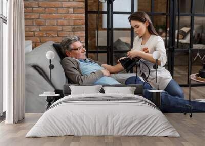 Nurse measure an old man blood pressure. An elderly patient with high blood pressure at home bed Wall mural