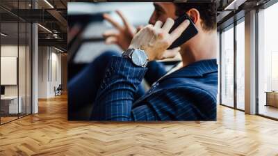 Portrait of bearded successful man sitting in cafe near windows, speak with someone by phone. Have a expensive watch. Wall mural