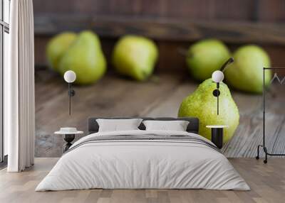 one fresh ripe organic yellow pear on rustic wooden brown table with defocused pears on background. Selective focus. Horizontal with copy space. For design about agricilture, fruit and healthy food Wall mural