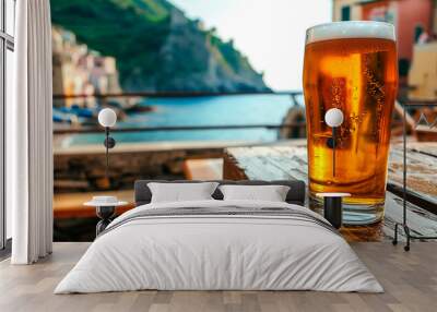 A glass of fresh beer against the backdrop of the blue sea and rocky coast. Top view of a beautiful landscape. Wall mural