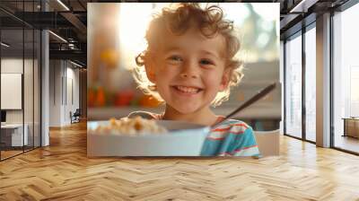 The child is having breakfast. The child eats cereal. Little boy at the dining table in the kitchen. Healthy balanced nutrition for children Wall mural