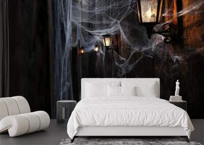 Dark alley with cobwebs illuminated by lanterns, creating a spooky and mysterious atmosphere Wall mural