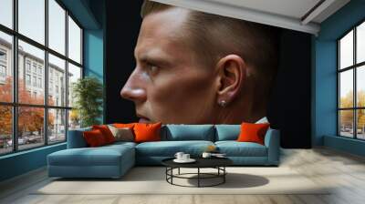 Profile view of a stylish man showcasing a slicked-back undercut hairstyle against a dark background Wall mural