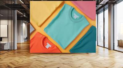 Vibrant display of neatly arranged t-shirts in various colors in a flat lay composition Wall mural