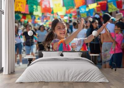 Young girl is smiling and dancing with her arms outstretched at a lively street festival Wall mural