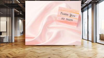 Thank-you note with Thank You so much inscription on pastel pink silk background: the concept of manifestation of gratitude and appreciation. Wall mural