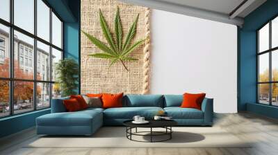 Cannabis leaf on burlap fabric with white background Green natural textile Wall mural