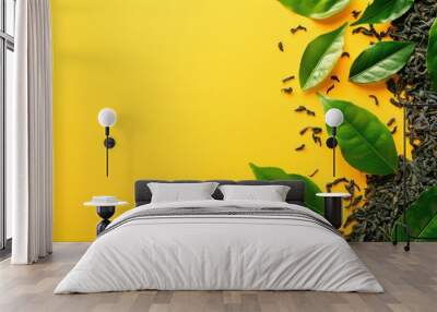 Loose leaf black tea with fresh green leaves on vibrant yellow background Wall mural