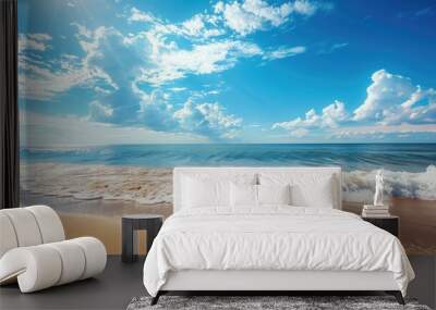 Scenic beach with waves crashing on shore, under bright blue sky clouds Wall mural