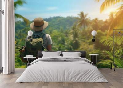 Solo traveler with backpack gazing at a tropical forest landscape Wall mural