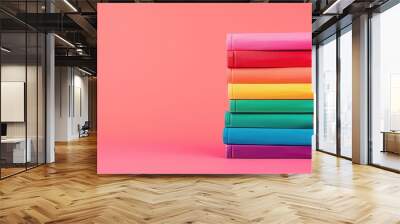 Stack of colorful books on pink background, LGBTQ+ concept Wall mural