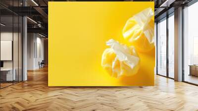 Two white deflated balloons on yellow background Wall mural