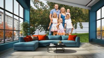 Happy large family with children in garden, apple tree on background. Wall mural