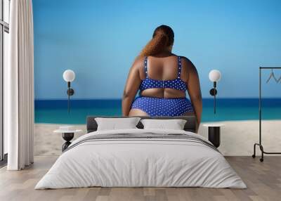 Plus size girl in a swimsuit on the beach. Wall mural