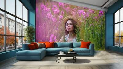 a girl in a straw hat in a field of flowers Wall mural