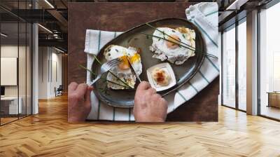 Open sandwiches with dark rye bread with cheese, egg and green onions. Elderly woman hands over sandwiches.Healthy natural breakfast. View from above. Wall mural