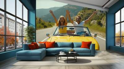 Happy couple driving convertible car on the road - Boyfriend and girlfriend with arms up having fun on a rental auto Wall mural