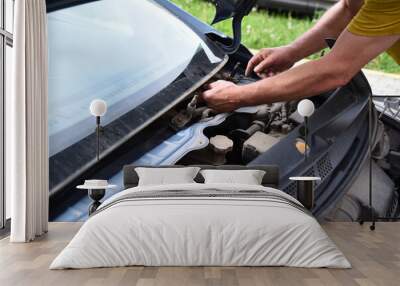 The open hood of the car with a view of the engine and the mechanisms of the car. Male hands of an auto mechanic for car repair Wall mural