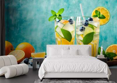 Refreshing summer lemonade with blueberries, orange, lime and mint in glasses. Wall mural