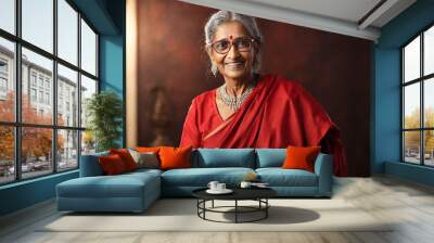 Portrait of a smiling Indian senior woman in red saree and eyeglasses Wall mural