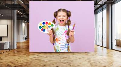 Development of children's creativity and drawing with paints. A beautiful girl with paints, brushes and palette in her hands on a purple isolated background. Wall mural