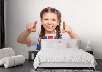 English language courses. A little girl with a big smile with the flag of Great Britain on an isolated white background. Wall mural