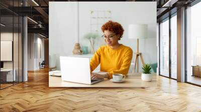 African american girl using laptop at home office looking at screen typing chatting reading writing email. Young woman having virtual meeting online chat video call conference. Work learning from home Wall mural