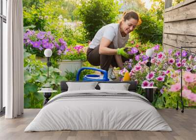 Gardening and agriculture concept. Young woman farm worker gardening flowers in garden. Gardener planting flowers for bouquet. Summer gardening work. Girl gardening at home in backyard Wall mural