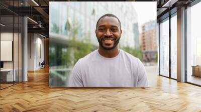 Happy african american man smiling outdoor. Portrait of young happy man on street in city. Cheerful joyful handsome person guy looking at camera. Freedom happiness carefree happy people concept Wall mural