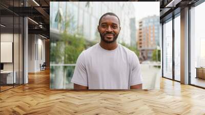 Happy african american man smiling outdoor. Portrait of young happy man on street in city. Cheerful joyful handsome person guy looking at camera. Freedom happiness carefree happy people concept Wall mural