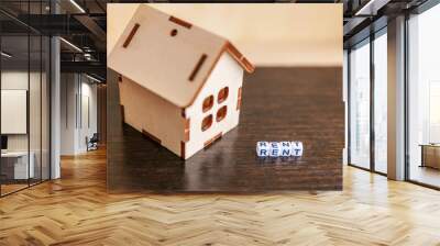 Miniature toy model house with inscription RENT letters word on wooden backdrop. Eco Village abstract environmental background. Real estate mortgage property insurance sweet home ecology rent concept Wall mural