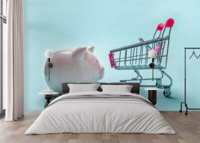 Sale buy mall market shop consumer saving and budget concept. Small supermarket grocery push cart for shopping with piggy bank isolated on blue pastel colourful trendy background Wall mural