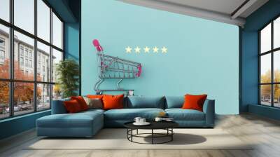 Small supermarket grocery push cart for shopping toy with wheels and 5 stars rating isolated on pastel blue background. Retail consumer buying online assessment and review concept. Wall mural