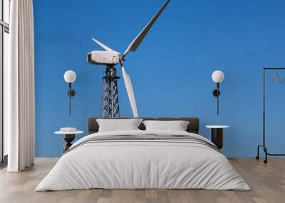 View to electric windmill on a tower in clear blue cloudless sky.  Wall mural